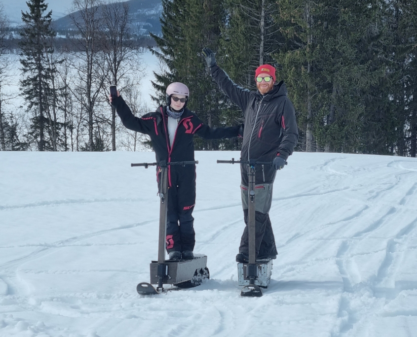 To personer på elektrisk snøsparkesykkel