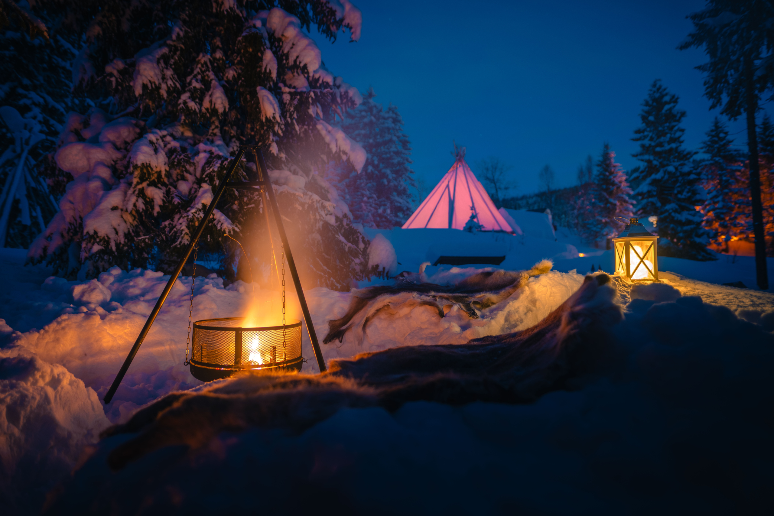 Bålpanne i forgrunnen og lavvo i bakgrunnen
